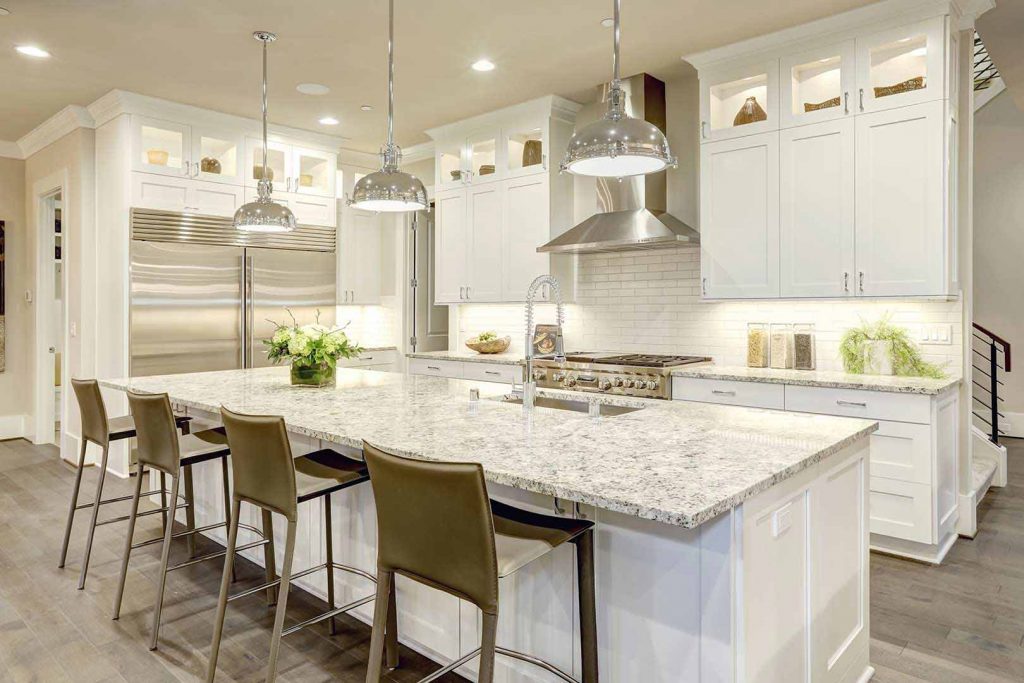 Kitchen with large white island with granite top